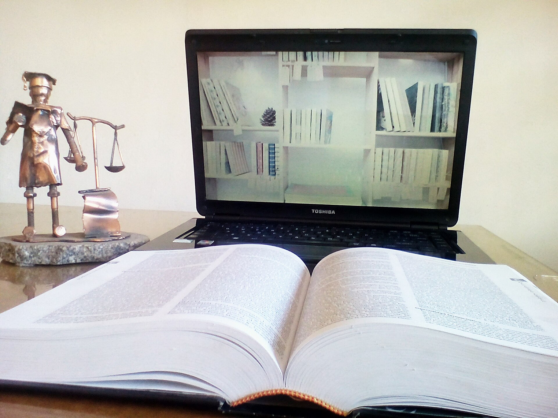 Student using AI study tools on a laptop with books and notes at a desk in a bright workspace