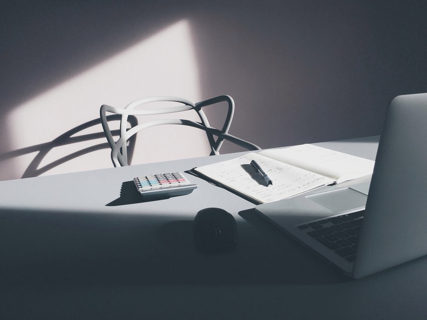 Person editing documents on a MacBook in an office